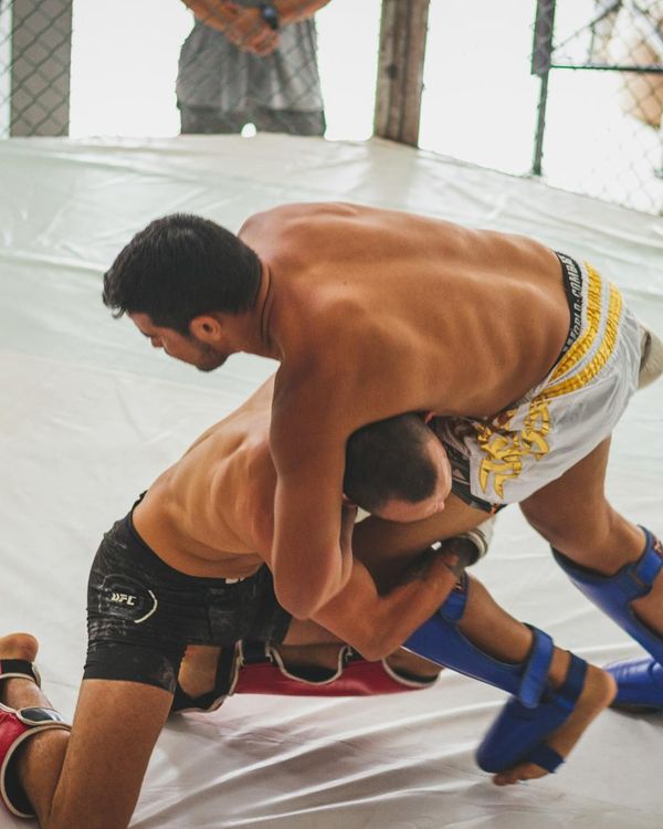 Man in athletic gear performing a foundational strength movement with focus.